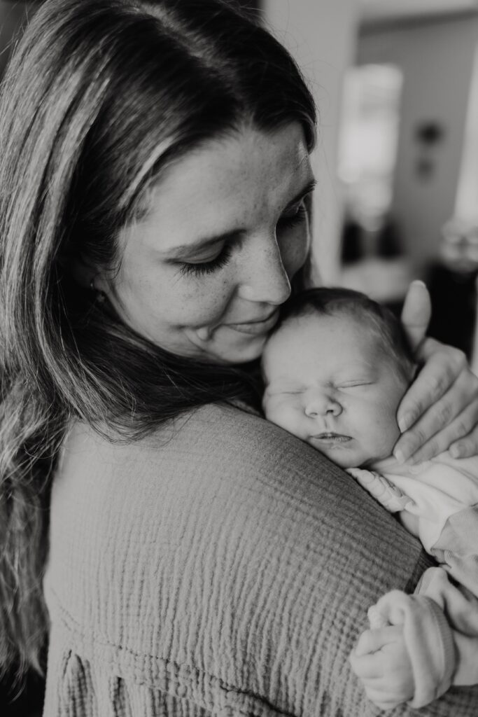 baby schlaeft auf dem arm seiner mutter bei neugeborenenshooting