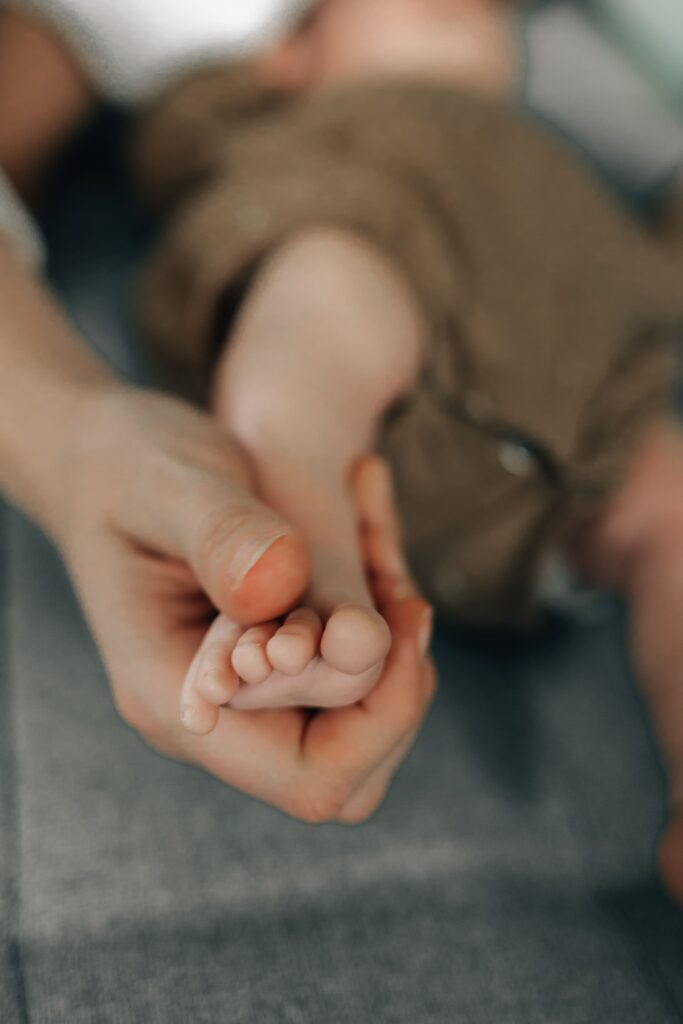 mutter hat babyfuss in der hand