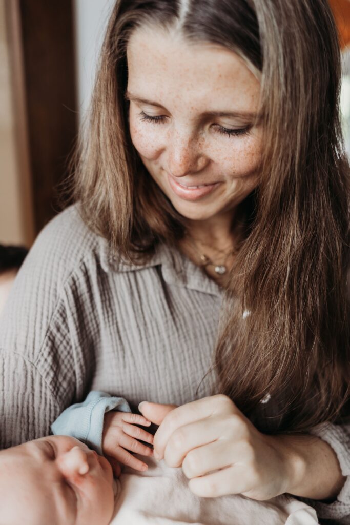 baby schlaeft auf dem arm seiner mutter bei neugeborenenshooting