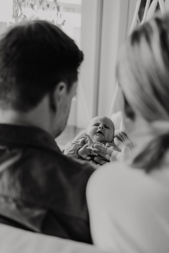 junge eltern sitzen mit baby auf dem sofa