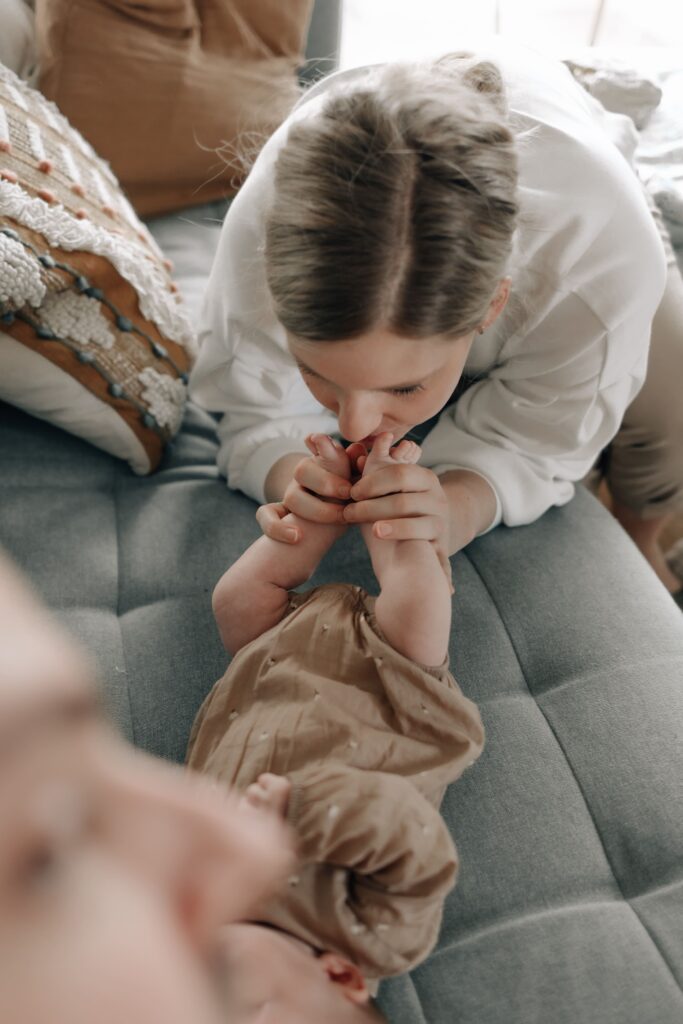 mama haelt die fuesse ihres baby in den haenden und kuesst sie