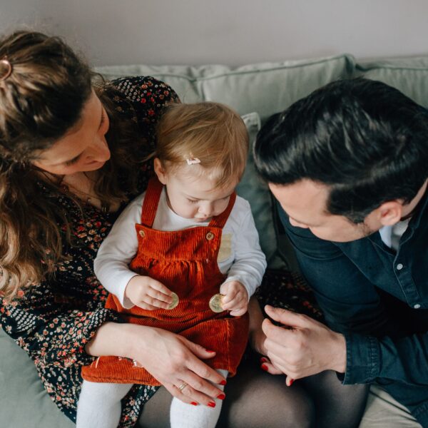 Familie sitzt mit kleinkind auf dem sofa bei familienshooting