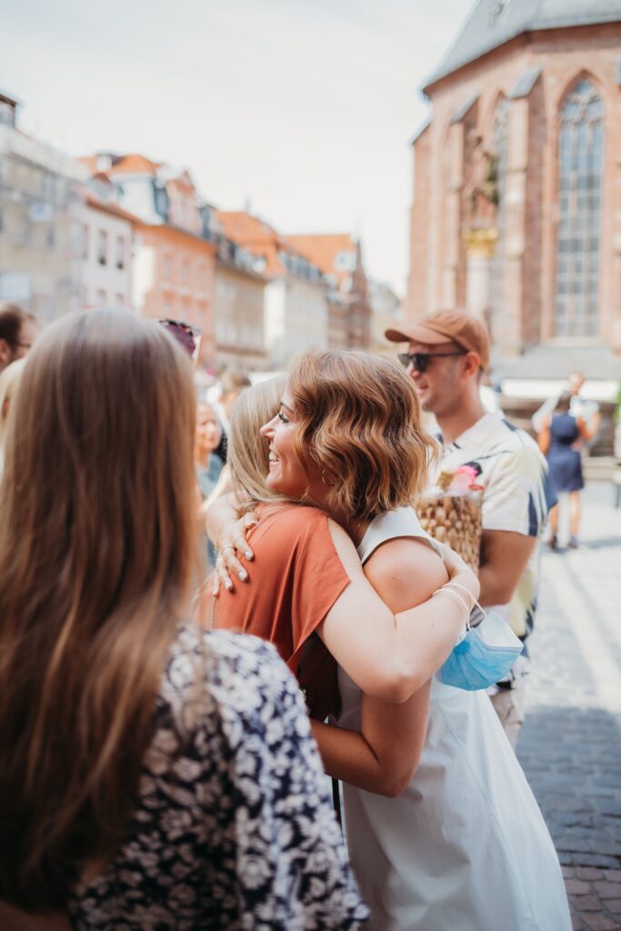 frau umarmt andere frau bei sektempfang hochzeit