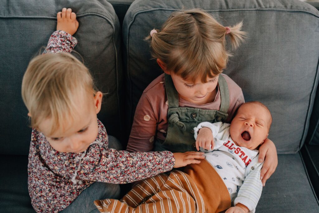 baby gaehnt und liegt auf dem schoss von großer schwester