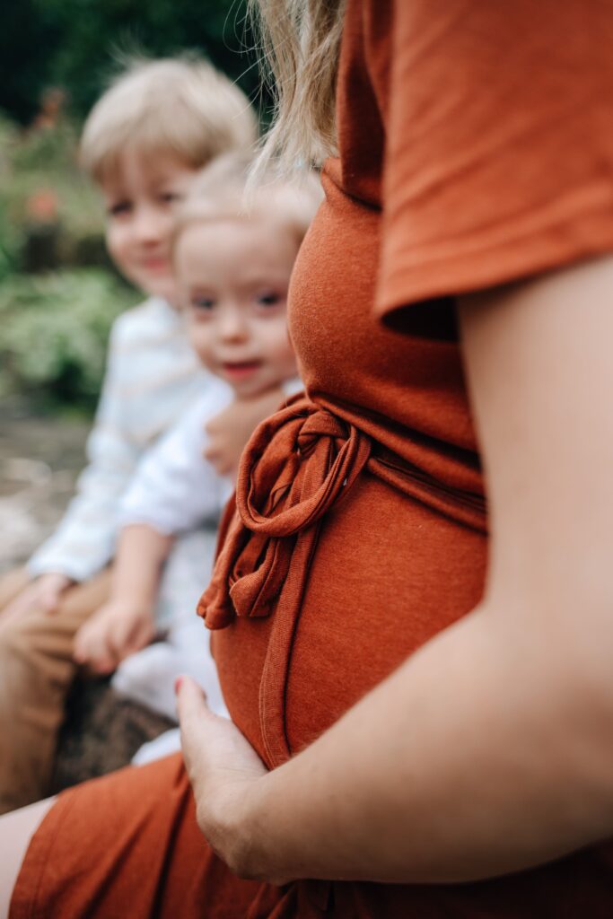 kinder sehen sich den babybauch von ihrer mama an bei einem fotoshooting in sinsheim