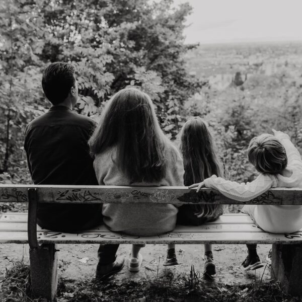 familie sitzt auf einer bank und schaut bei fotoshooting in die ferne